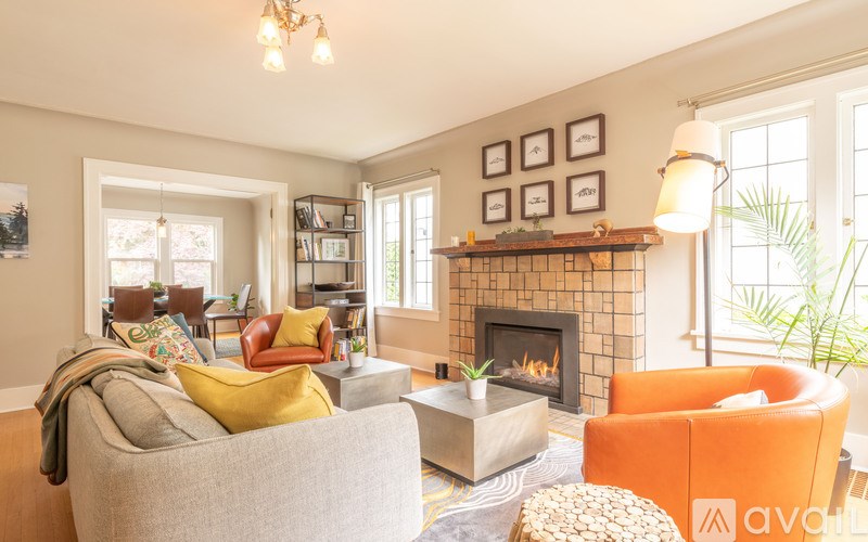 A living room with a fireplace and a grey couch.