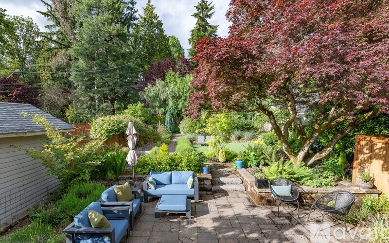 A backyard with a blue couch and a white umbrella.