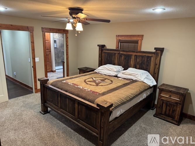 A bedroom with a large bed and a ceiling fan.
