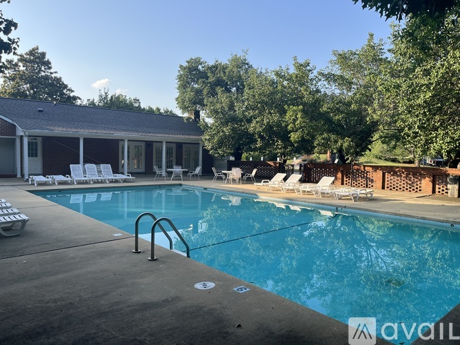 A pool with a metal ladder and a house with a white door.