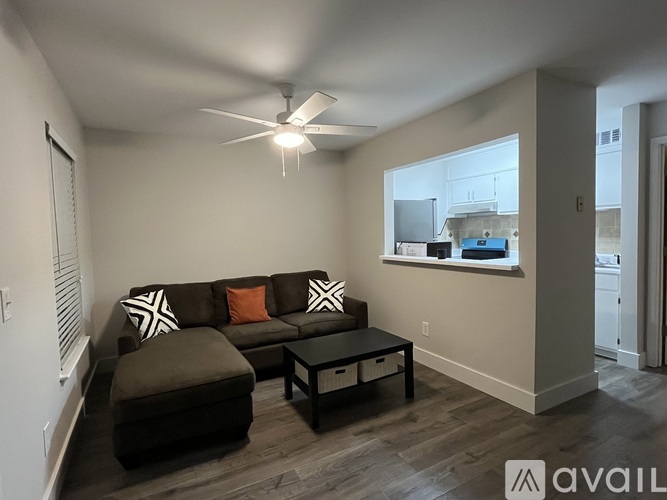A living room with a brown couch and a black coffee table.