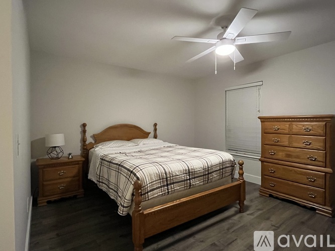 A bedroom with a bed, dresser, and nightstand.