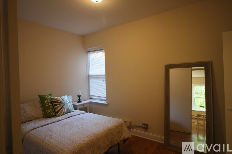 A bedroom with a bed, a window, and a mirror.