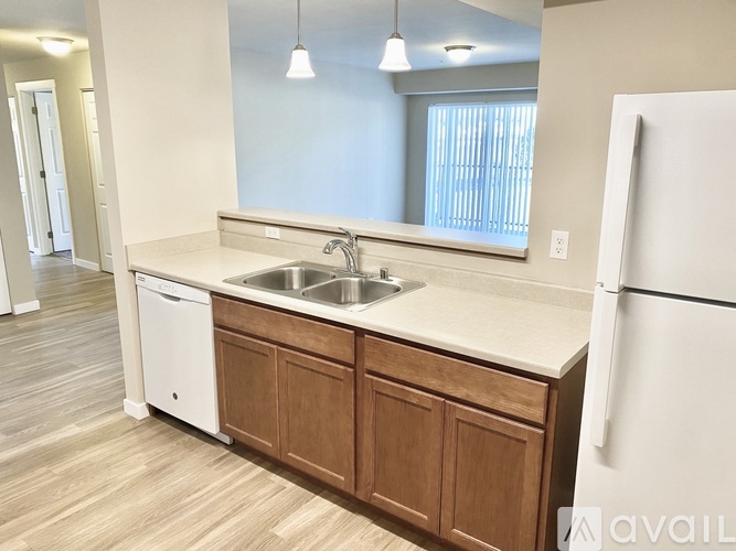 A kitchen with a white stove and wooden cabinets.