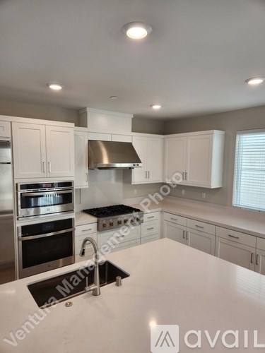 A kitchen with white cabinets and stainless steel appliances.