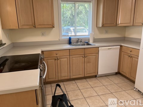 A kitchen with wooden cabinets and a white dishwasher.