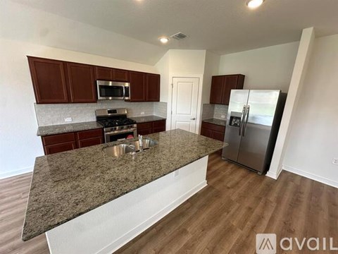 A kitchen with granite countertops and stainless steel appliances.