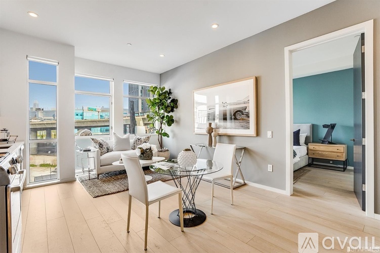 A well-lit, spacious living room with a dining area and a view of the city.