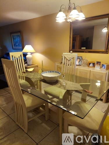 A dining room with a glass table and chairs.