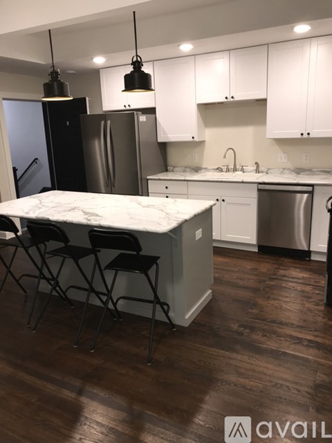 A kitchen with a table and chairs in front of a refrigerator.