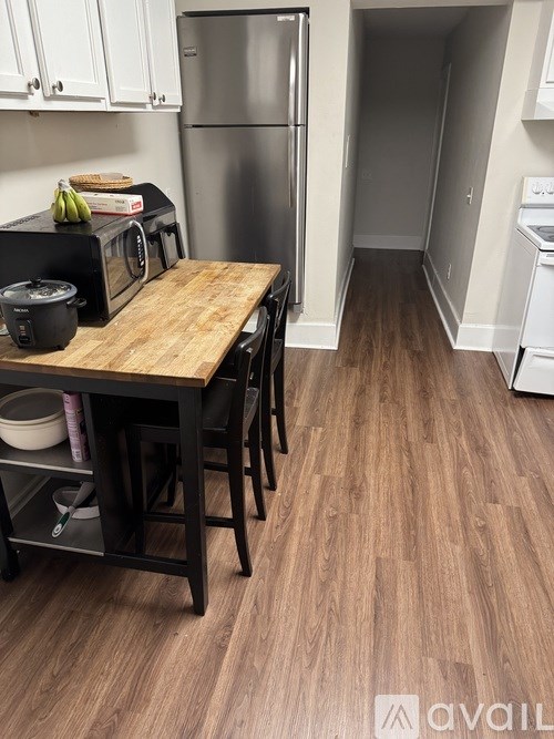 A kitchen with a wooden table and black chairs.