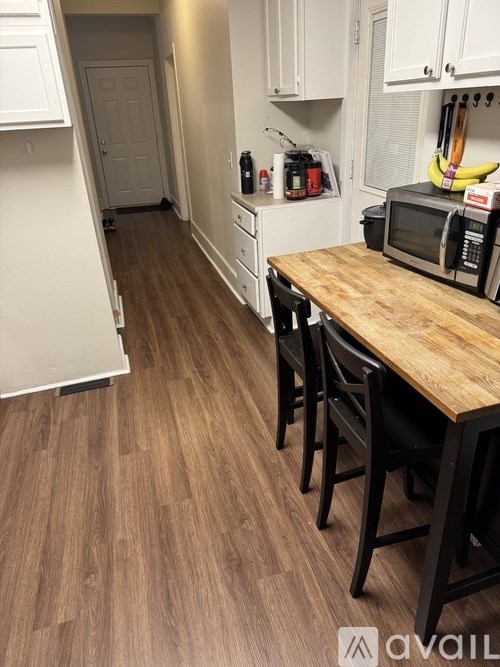 A kitchen with a wooden table and chairs.