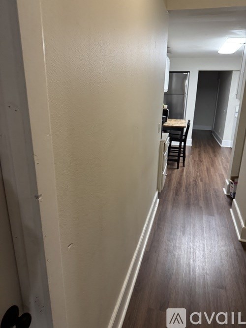 A hallway with a table and chairs in the distance.