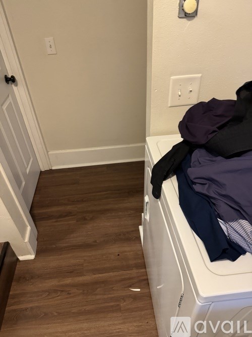 A white washing machine with a black top and a blue shirt on it.