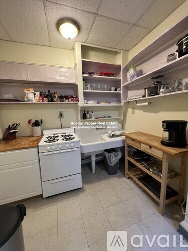A kitchen with a stove top oven and a coffee maker.
