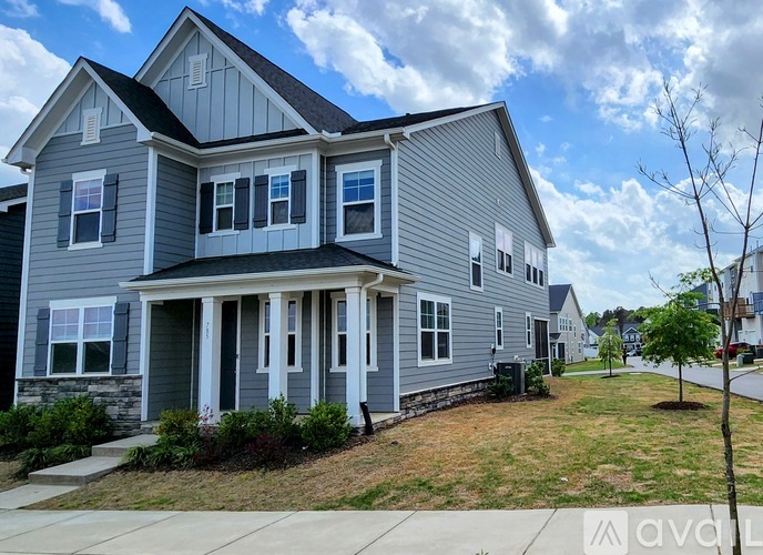 A two-story house with a grey exterior and white trim.