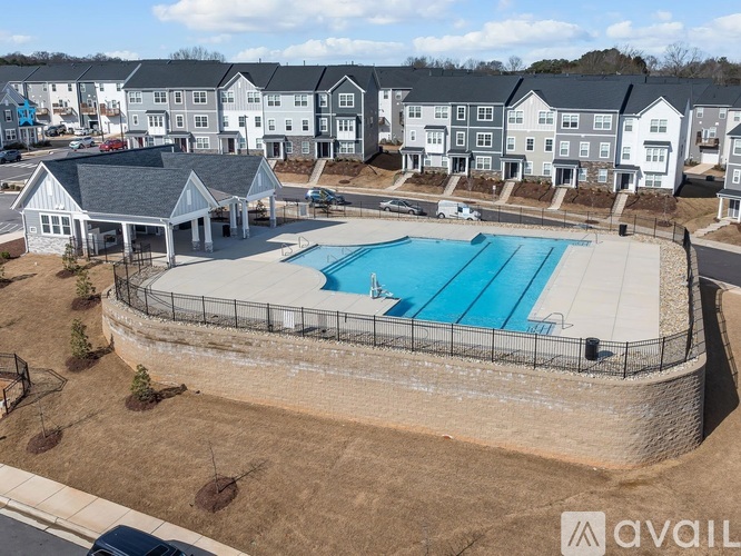 A swimming pool surrounded by a fence and a building in the background.