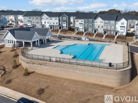 A swimming pool surrounded by a fence and a building in the background.