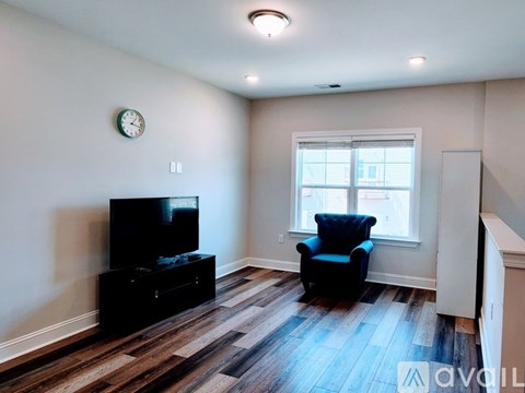 A living room with a black chair and a television.