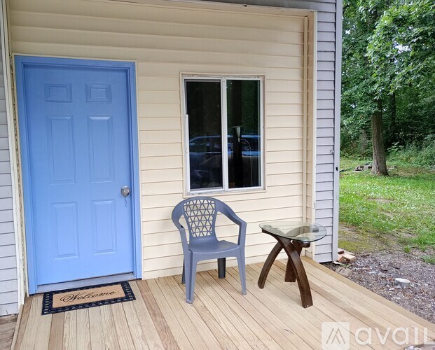 A blue chair sits on a wooden deck next to a blue door.
