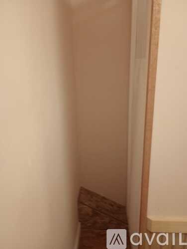 A small room with a brown cushion on the floor.