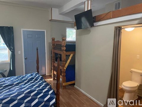 A bedroom with a bunk bed and a toilet in the corner.