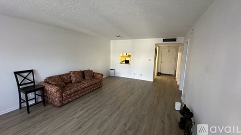 A living room with a brown couch and a black chair.