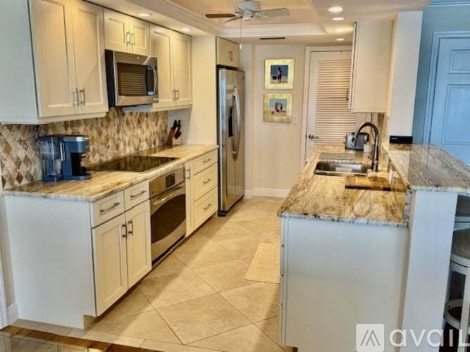 A kitchen with white cabinets and a granite countertop.