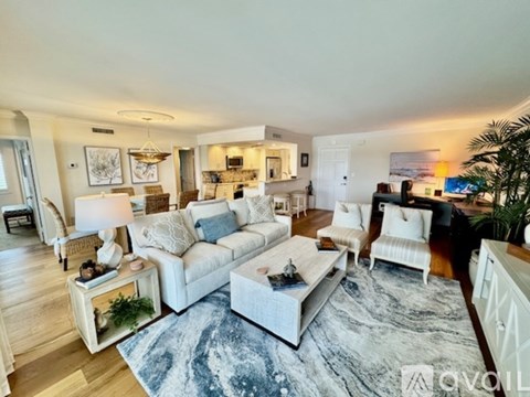 A living room with a white couch and a rug.