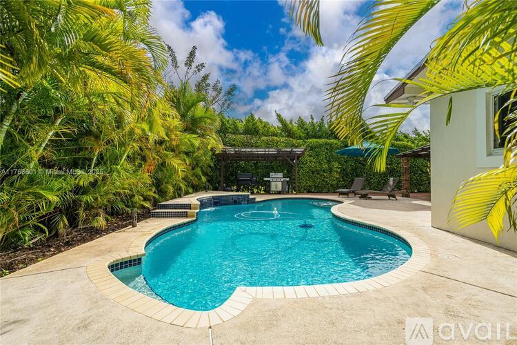 A heart-shaped pool surrounded by palm trees and a house.