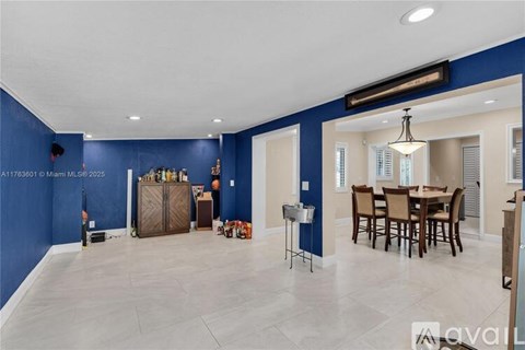 A living room with a dining table and chairs.