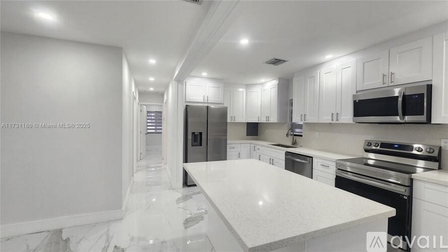 A modern kitchen with white cabinets and appliances.
