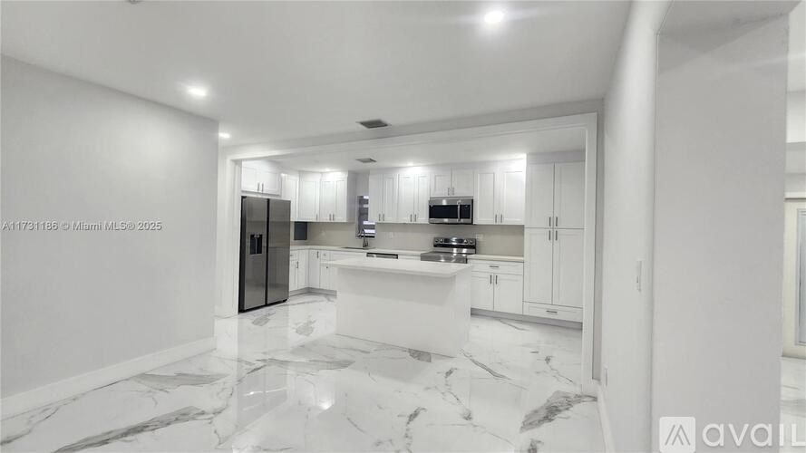 A modern kitchen with marble flooring and white walls.