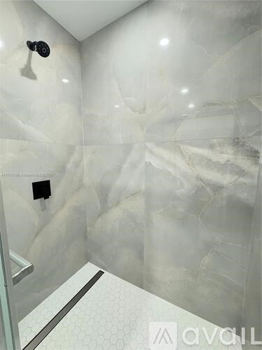 A bathroom with a marble wall and a white floor.