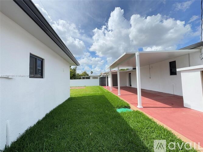 A white building with a red walkway in front of it.