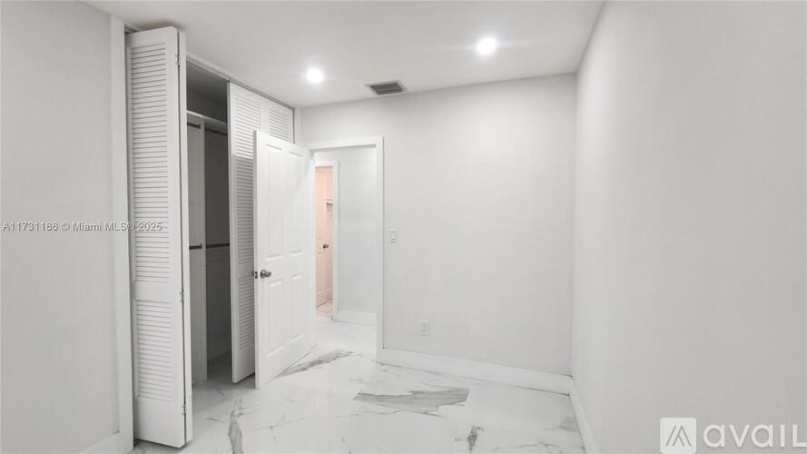 A room with a white door and a white wall.