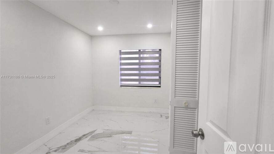 A room with a door, window, and a tiled floor.