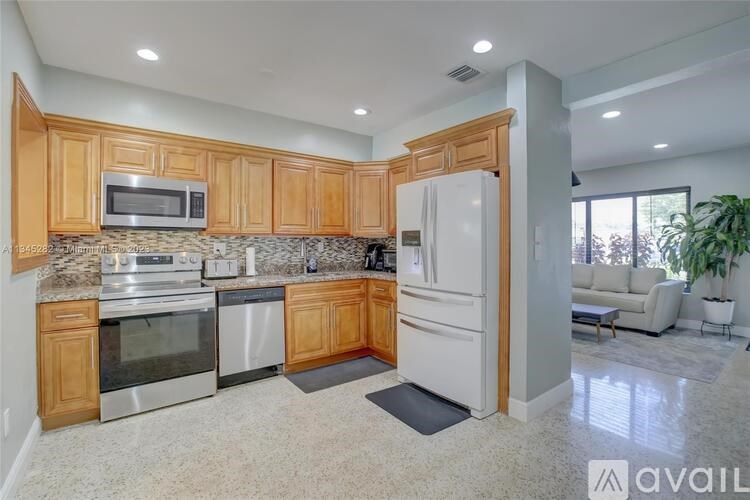 A kitchen with wooden cabinets and a white refrigerator.