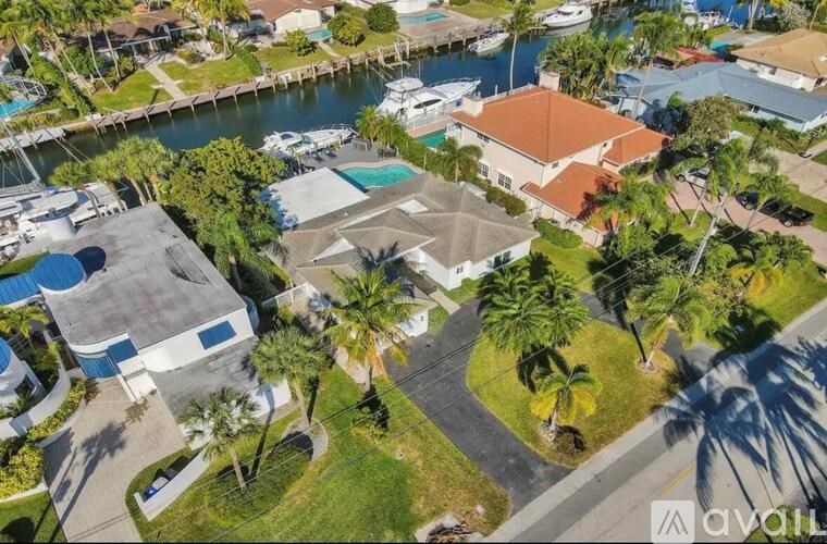 A house with a pool surrounded by palm trees.