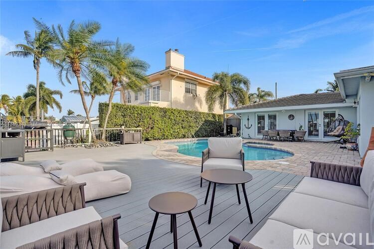 A poolside patio with a table and chairs.