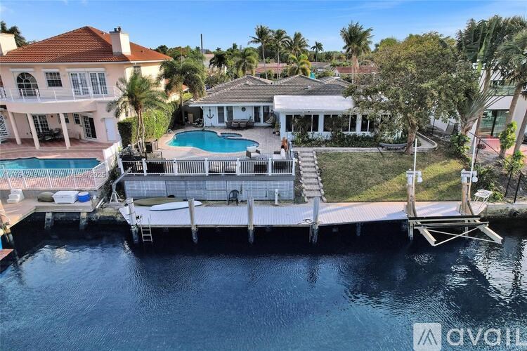 A house with a pool and docked boats.