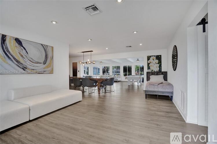 A modern bedroom with a large bed and a painting on the wall.