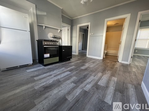A kitchen with a white refrigerator and a black stove top oven.