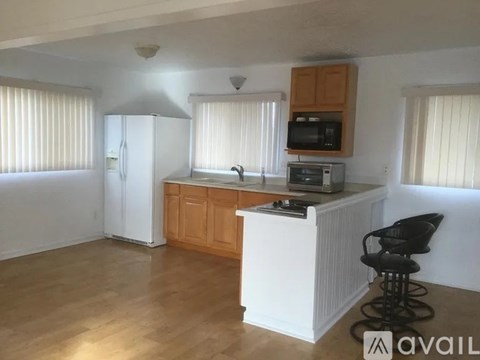 A kitchen with wooden cabinets and a white refrigerator.