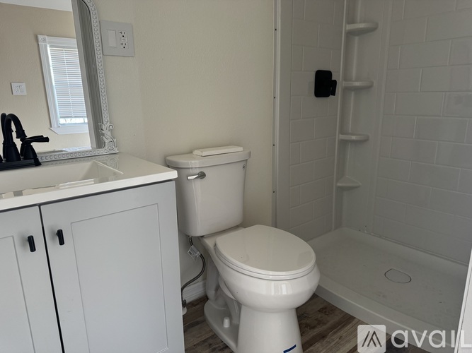 A white toilet in a bathroom with a white sink and a white cabinet.