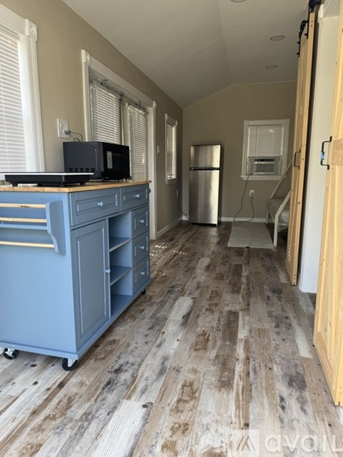A kitchen with a blue cabinet and a TV on top of it.