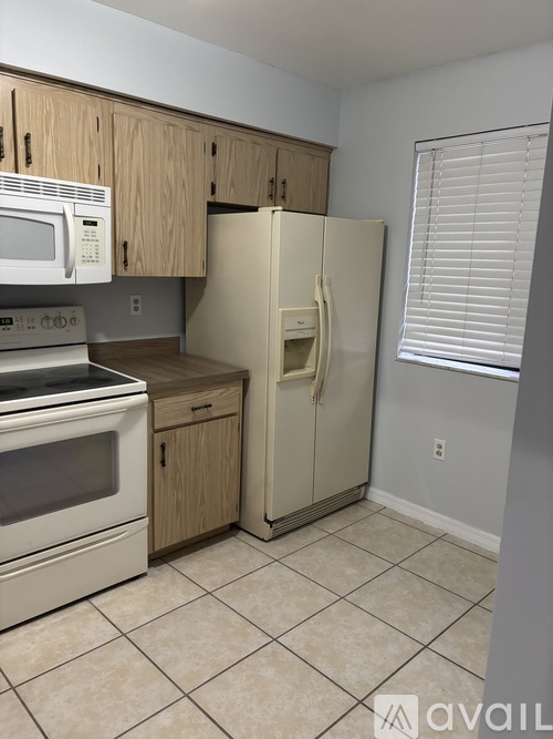 A kitchen with a white refrigerator, white oven, and white microwave.