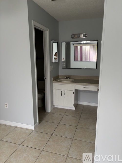 A bathroom with a white vanity and a mirror.