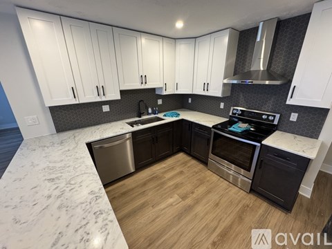 A kitchen with white cabinets and a marble countertop.