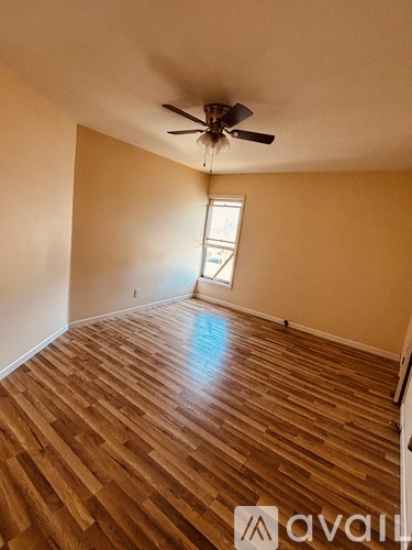 A room with wooden flooring and a ceiling fan.